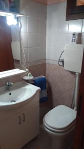 a bathroom with a white toilet and a sink at Casa Anna in Bosa +19 photos