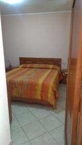 a bedroom with a bed with a colorful comforter at Casa Anna in Bosa