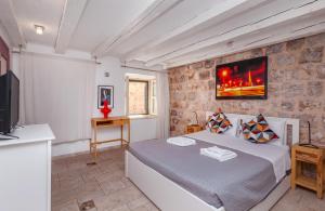 ein Schlafzimmer mit großem Bett und Fernseher in der Unterkunft Apartment Potkova in Dubrovnik