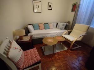 a living room with a couch and a table and chairs at House with a garden 50m from the sea in Pag