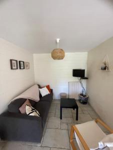 a living room with a couch and a table at Gîte à la campagne in Le Mesnil-Villeman