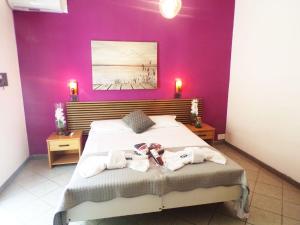 a bedroom with a large bed with purple walls at Hotel Litton Rimini nuova gestione in Rimini +4 photos