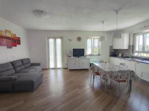 a kitchen and living room with a table and a couch at La casa delle Mogge in Piazza