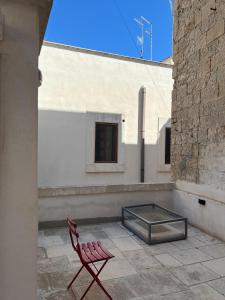 a red chair sitting on a patio next to a building at Dimora Noblac in Monopoli