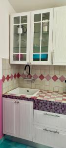 a kitchen with white cabinets and a sink at Casa Vacanze Miranda in Torre Dei Corsari