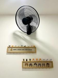 a fan hanging on a wall next to a shelf at Neko Homes at i-City - WiFi TV Box 1 Carpark in Shah Alam