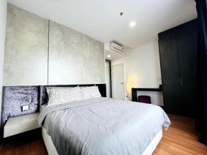 a bedroom with a large bed and a concrete wall at Novel Homes at i-City - WiFi TV Box 1 Carpark in Shah Alam