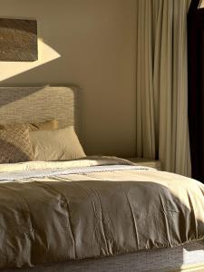 a bedroom with a bed with a brown comforter at WeTake Hawana in Salalah +17 photos