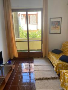 a living room with a couch and a window at Casa Sofia in Villasimius