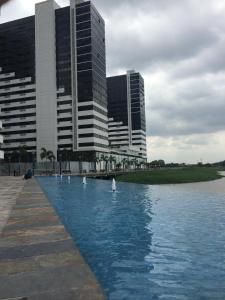 a group of swans in the water in front of buildings at Torre Bellini in Guayaquil