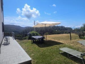 a patio with a table and an umbrella at La casa delle Mogge in Piazza