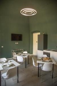 a dining room with tables and white chairs at Maison Le Blanc Luxury B&B in Giovinazzo
