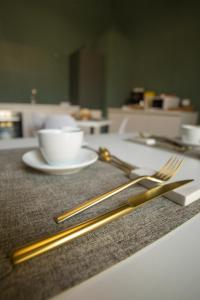 a table with two gold chopsticks and a cup of coffee at Maison Le Blanc Luxury B&B in Giovinazzo