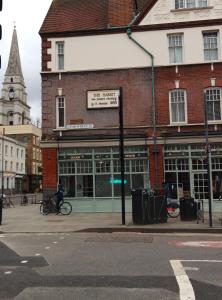Un edificio en una calle de la ciudad con una persona en bicicleta. en Alexandra Palace WILD CARD Woodgreen and Crouch End London, en Londres