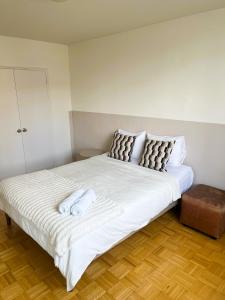 a large white bed with two towels on it at The Charming Downtown Stop in Toronto