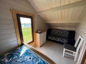 een kleine kamer met een bed en een raam bij Domek nad jeziorem Jan, Giże in Giże
