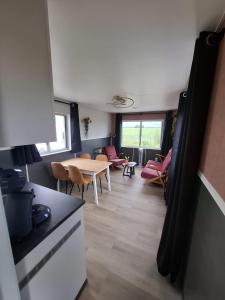 a kitchen and living room with a table and chairs at Chalet Julia, Minicamping de Grutte Earen in Burum +8 photos