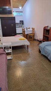 a room with two beds and a table and a kitchen at Monoambiente amplio in Posadas +4 photos