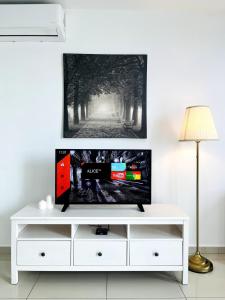 a living room with a tv on a white entertainment center at Oasis Homes at i-City - WiFi TV Box and 1 Carpark in Shah Alam