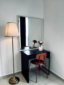 a desk with a mirror and a chair and a lamp at Oasis Homes at i-City - WiFi TV Box and 1 Carpark in Shah Alam