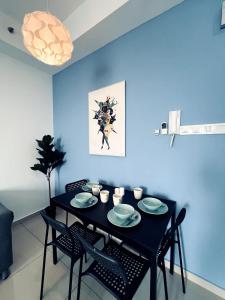 a blue dining room with a black table and chairs at Oasis Homes at i-City - WiFi TV Box and 1 Carpark in Shah Alam