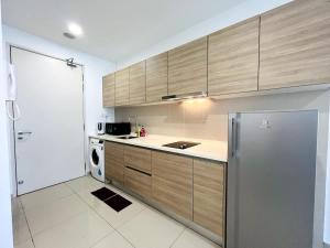 a kitchen with wooden cabinets and a refrigerator at Onyx Homes at i-City - WiFi TV Box and 1 Car Park in Shah Alam