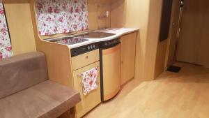 een kleine keuken met een spoelbak en een fornuis bij Domek, caravaning nad jeziorem, Giże in Giże