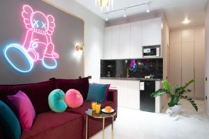 アルマトイにあるLa Talle apart hotelのネオンサインが付いた紫色のソファのあるリビングルーム