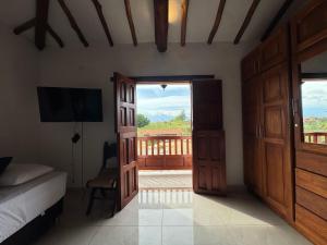 a bedroom with a bed and a door with a balcony at Hotel Palais Barichara in Barichara