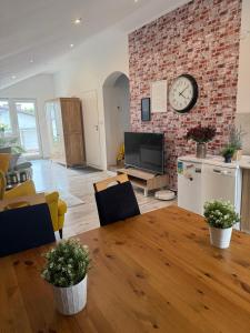 a living room with a table and a clock on a brick wall at 120m2 APARTAMENT LAS I JEZIORO in Człuchów