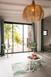a living room with a plate of food on a table at Turtle Rock 7 chambres in Les Anses-dʼArlets