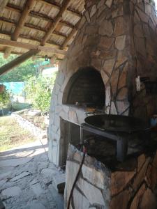 a stone oven with a pizza in it at Apartmani Mihajlovic Sisevac in Sisevac