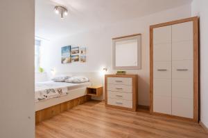 une chambre avec un lit, une commode et un miroir dans l'établissement Solis Apartment, à Korčula