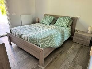 a bedroom with a bed with a wooden floor at Gîte Relais du Doulay in Saint-Fulgent