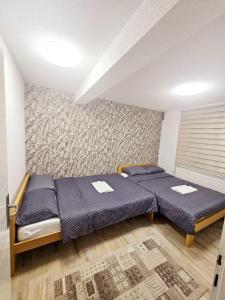 Un dormitorio con dos camas en una habitación. en AMAI Exclusive, en Tuzla