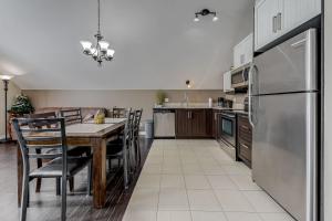 una cocina con una mesa y un refrigerador en Le Haut-Perche - Spa and River View, en Petite-Rivière-Saint-François