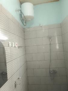 a bathroom with a shower with white tile at Sabyinyo Landscape resort in Ruhengeri