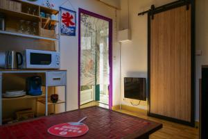 a living room with a door open to a kitchen at Studio theme japonais - 2 personnes in Olonne-sur-Mer