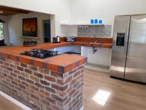 a kitchen with a brick counter top and a refrigerator at ANIMATERRA Luxury Lodge SISGA in Chocontá