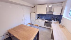 a kitchen with white cabinets and a wooden table at Urlauber und Monteure willkommen in Baesweiler