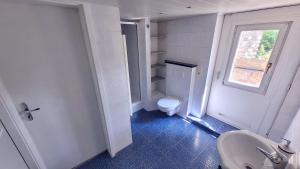 a bathroom with a toilet and a sink and a window at Urlauber und Monteure willkommen in Baesweiler