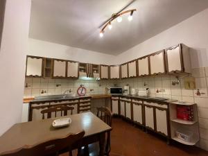 a kitchen with brown cabinets and a wooden table at Casa Vacanza Anna in Verbania +14 photos