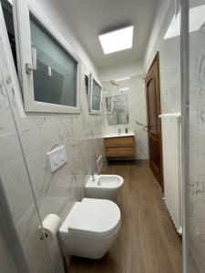 a white bathroom with a toilet and a sink at Casa Vacanza Anna in Verbania