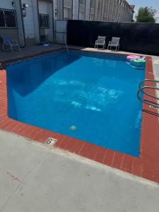 a large blue swimming pool with two chairs in it at Nampa Inn & Suites in Nampa