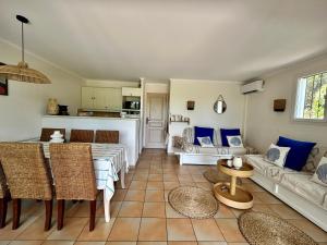 un soggiorno con un divano e un tavolo di Les Restanques Bruyeres 2001 proche piscine a Grimaud