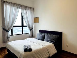 a bedroom with a bed with two shoes on it at Skyline Homes at i-City - WiFi TV Box 1 Carpark in Shah Alam