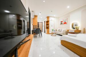 a bedroom with a bed and a living room at CĂN HỘ VINHOMES GRAND PARK QUẬN 9 Studio in Gò Công