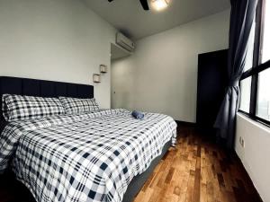 a bedroom with a bed with a checkered blanket at Skyline Homes at i-City - WiFi TV Box 1 Carpark in Shah Alam