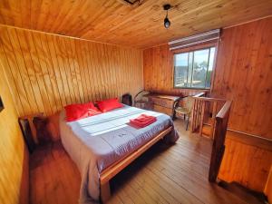a bedroom with a bed with red pillows on it at Lilafken Apart Pichilemu in Pichilemu