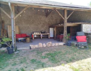 a patio with red chairs and a table and a picnic table at Parenthèse Aiyanna in Moux-en-Morvan